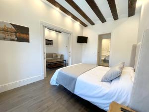 a bedroom with a bed and a living room at Apartamentos El Mirador del Poeta in Salamanca