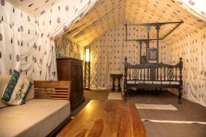 a room with a bed and a couch in a tent at Eco Adventure Resorts Khhairabera in Bāghmundi