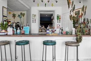 a bar with green stools in front of a counter at The Cimon in Torquay