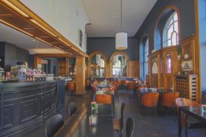 a restaurant with tables and chairs and a bar at Hotel La Royale in Leuven