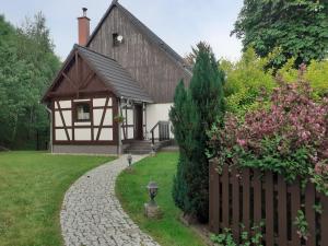 een klein huis met een hek en een tuin bij Agroturystyka Łysa Góra in Jelenia Góra