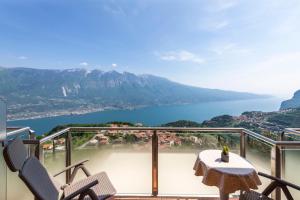 a balcony with a table and chairs and a view of a lake at Hotel Pineta Campi in Tremosine Sul Garda