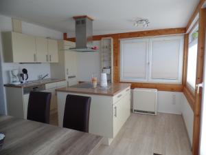 a kitchen with white cabinets and a table with chairs at Objekte im Umland Ostseeschatulle in Neustadt in Holstein