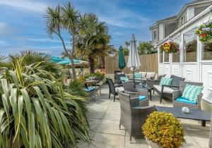 a patio with chairs and tables and umbrellas at The Cimon in Torquay