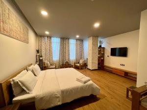 ein Schlafzimmer mit einem großen Bett und einem Flachbildfernseher in der Unterkunft Magen Hills in Ukhrul