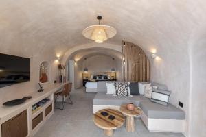 a living room with a couch and a bed at The Exotic Cave Suite in Oia