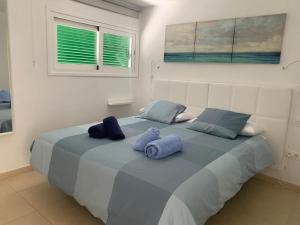 a bedroom with a large bed with blue pillows at SEA&RELAX in Puerto del Carmen