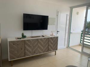 a flat screen tv on top of a wooden dresser at SEA&RELAX in Puerto del Carmen