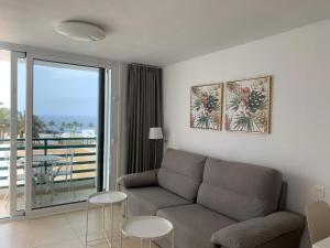 a living room with a couch and a balcony at SEA&RELAX in Puerto del Carmen