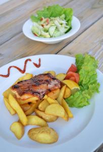 two plates of food with meat and french fries at Hotel Aquamarin in Bad Mitterndorf
