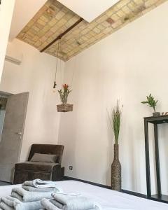 Cette chambre comprend un lit, une chaise et des serviettes. dans l'établissement Abbazia di San Paolo Appartamento Moderno, à Rome