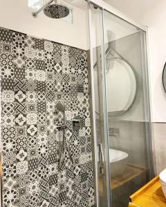La salle de bains est pourvue d'une douche et d'un mur en carrelage. dans l'établissement Abbazia di San Paolo Appartamento Moderno, à Rome