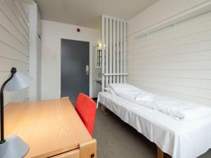 1 Schlafzimmer mit 2 Betten, einem Schreibtisch und einem Tisch in der Unterkunft Førde Sommarhotell in Førde