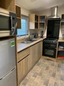 a kitchen with wooden cabinets and a stainless steel appliances at Nidd Way Holiday Let in Knaresborough