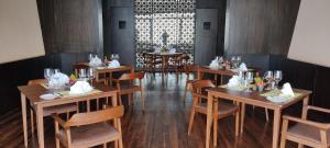 ein Esszimmer mit Holztischen und -stühlen in einem Restaurant in der Unterkunft Kavya Resort & Spa in Nagarkot