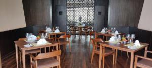a restaurant with wooden tables and chairs in a room at Kavya Resort & Spa in Nagarkot