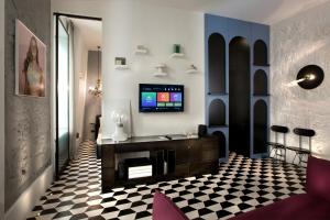 a living room with a tv and a checkered floor at CocoMorghen Apartment in Naples