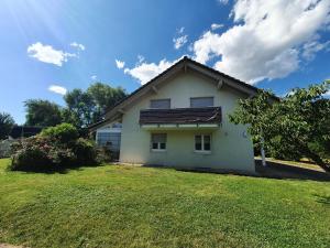ein kleines weißes Haus mit einem Rasenhof in der Unterkunft Klettgauperle - familien- und behindertengerechte Ferienwohnung in Griessen