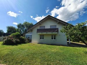 a small white house with a grass yard at Klettgauperle - familien- und behindertengerechte Ferienwohnung in Griessen
