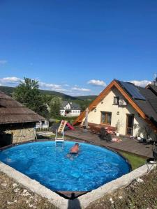 a man in a swimming pool in front of a house at Willa WIKTORIA in Krynica Zdrój