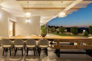 a dining room with a large wooden table and chairs at Elaida Villa, Heaven on Earth, By ThinkVilla in Perama