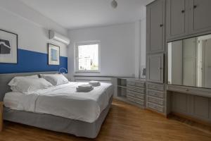 een slaapkamer met een groot wit bed en een raam bij Deco Marble Apt with Acropolis view in Athene