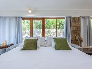 カルロフォルテにあるVilla Iole Apartmentのベッドルーム(緑の枕が付く大きな白いベッド付)