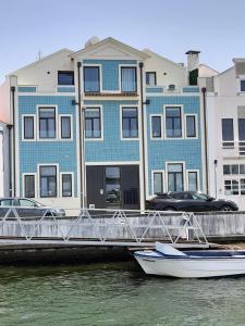 Light Blue Apartment في أفيرو: قارب في الماء امام مبنى