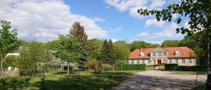 a large white house with a red roof at Ferienwohnung am Gutshaus Pamitz in Klein Bünzow