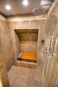 a bathroom with a shower with a bench in it at Romantic and historical maisonette in the center of Valletta MBAL1-1 in Valletta