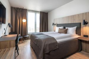 Una habitación de hotel con una cama grande y un escritorio. en Quality Airport Hotel Værnes, en Stjørdal