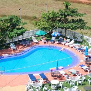 a swimming pool with chairs and umbrellas at Palmarinha de Goa in Calangute