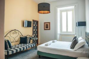a bedroom with a bed and a couch and a window at Hotel Casa Camilla in Verbania