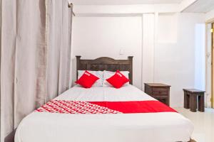 a bedroom with a bed with red pillows at OYO Hotel Punta Guadalupe, San Cristóbal de las Casas in San Cristóbal de Las Casas