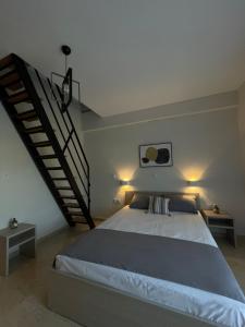 a bedroom with a large bed and a staircase at Nigdeli Studios in Stavros