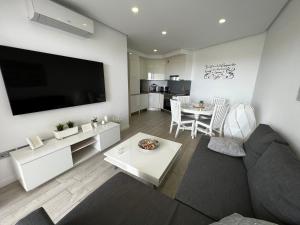 A television and/or entertainment centre at Ocean Garden Sunset Apartment - heated swimming pool Free WIFI