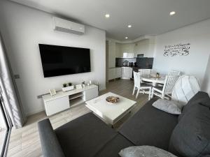A television and/or entertainment centre at Ocean Garden Sunset Apartment - heated swimming pool Free WIFI