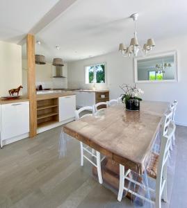 een keuken en eetkamer met een houten tafel en stoelen bij Maison chaleureuse, décoration raffinée in Clohars-Fouesnant