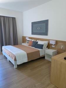 a bedroom with a large bed and a table at Relais del Borgo- Domo in Porto San Paolo