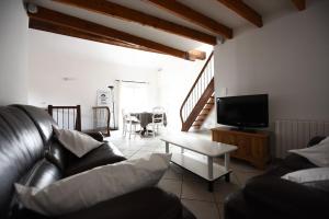a living room with a couch and a tv at Sète - LOFT 6 personnes. CENTRE VILLE / PORT in Sète