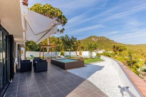 a patio with a table and chairs and a mountain at La Villa de los Mares in Bell-Lloch