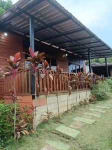 uma casa com uma cerca de madeira em frente em Maingern Maithong Resort em Sara Buri