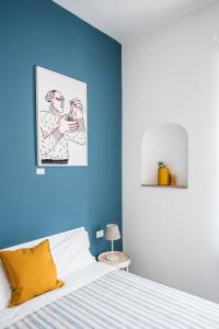 Dormitorio azul con cama y pared azul en Blunotte Torino - Piazza Arbarello en Turín