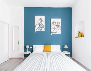 una camera da letto con un grande letto con pareti blu di Blunotte Torino - Piazza Arbarello a Torino