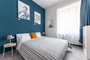 a bedroom with a bed and a blue wall at Blunotte Torino - Piazza Arbarello in Turin