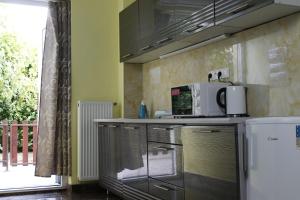 a kitchen with a counter with a microwave and a refrigerator at Apartmánový Garni Hotel Relax in Senec
