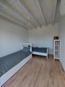 1 dormitorio con 2 camas y suelo de madera en Kotedžas Svencelės saloje, en Svencelė