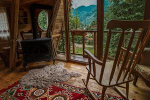 a living room with a fireplace and a rocking chair at Moromu Bungalows in Çamlıhemşin