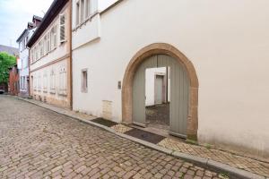 un edificio bianco con un arco accanto a una strada di Travel Homes - The Ancienne Poste, Petite Venise a Colmar