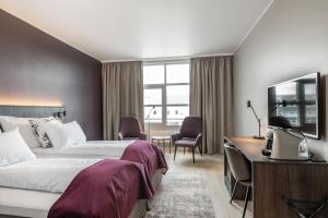 a hotel room with a bed and a desk at Quality Airport Hotel Værnes in Stjoerdal